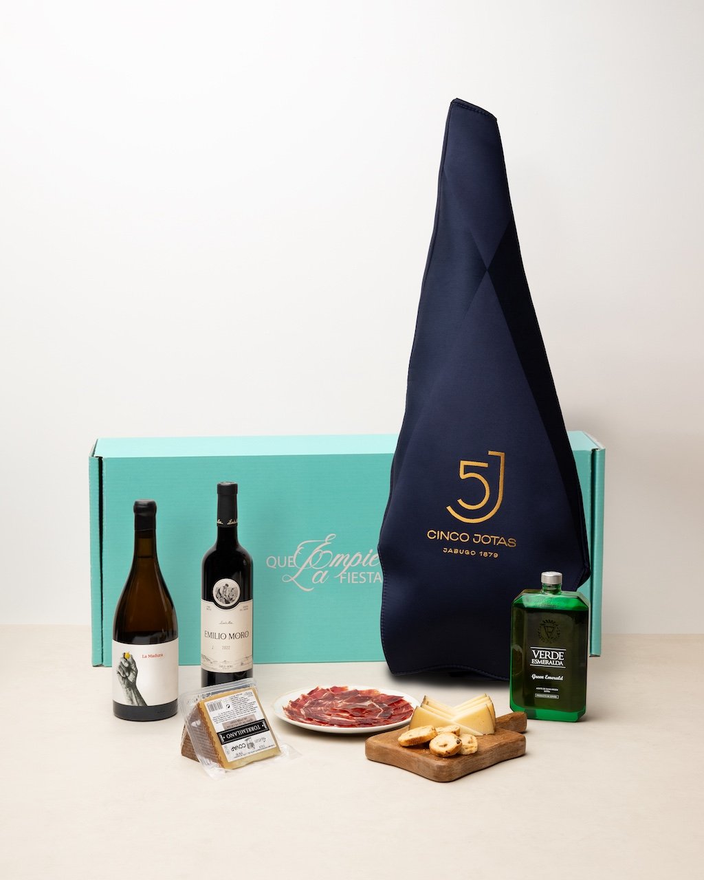 Lote de regalo de empresa con jamón ibérico Cinco Jotas, vinos, quesos y aceite de oliva, presentado en caja personalizada de Mireia Sanchis