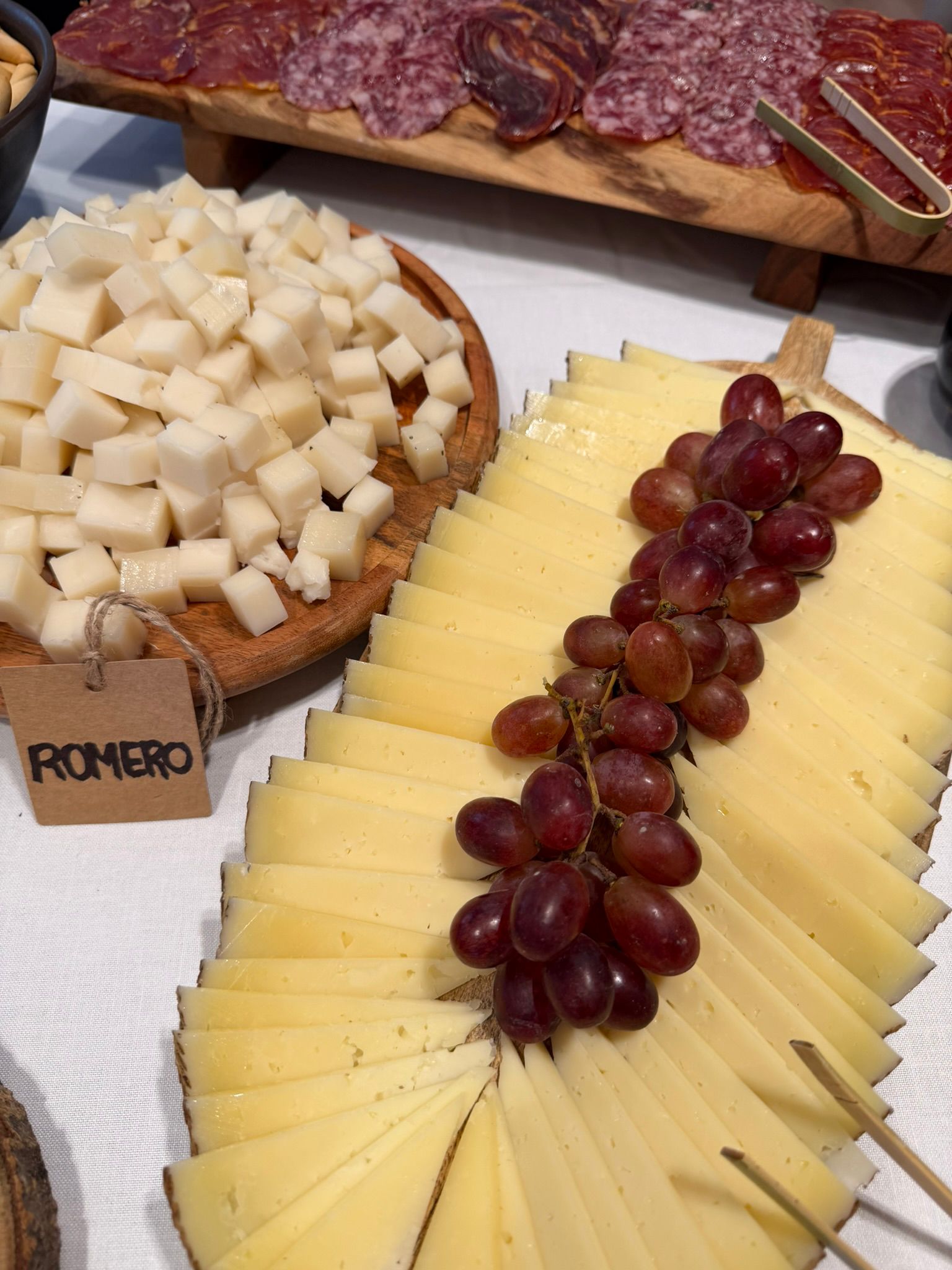 Tabla de buffet de quesos con uvas, frutos secos y confituras como complemento al jamón